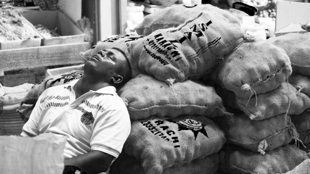 ein Mann schläft auf Kartoffelsäcke